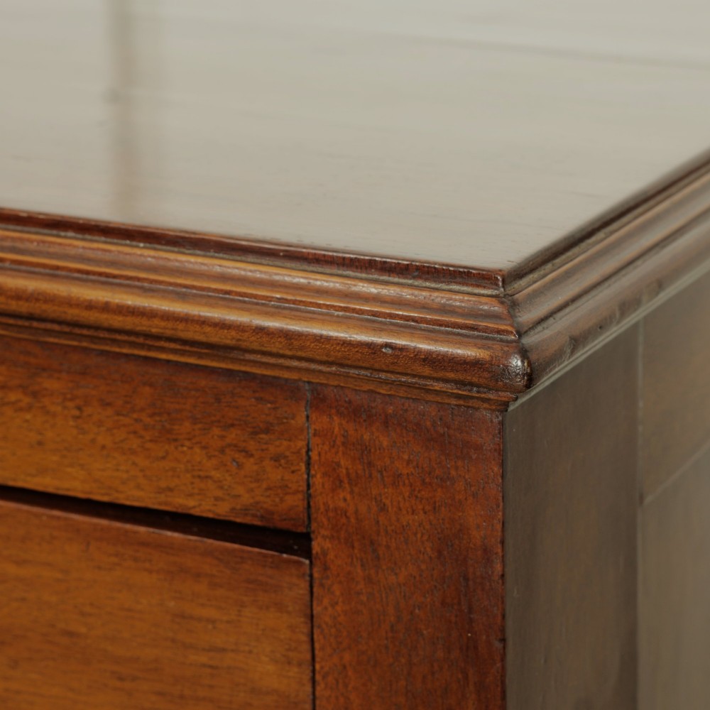 A late Victorian mahogany chest of drawers featuring two short drawers over two long drawers with brass handles on a plinth base. View V