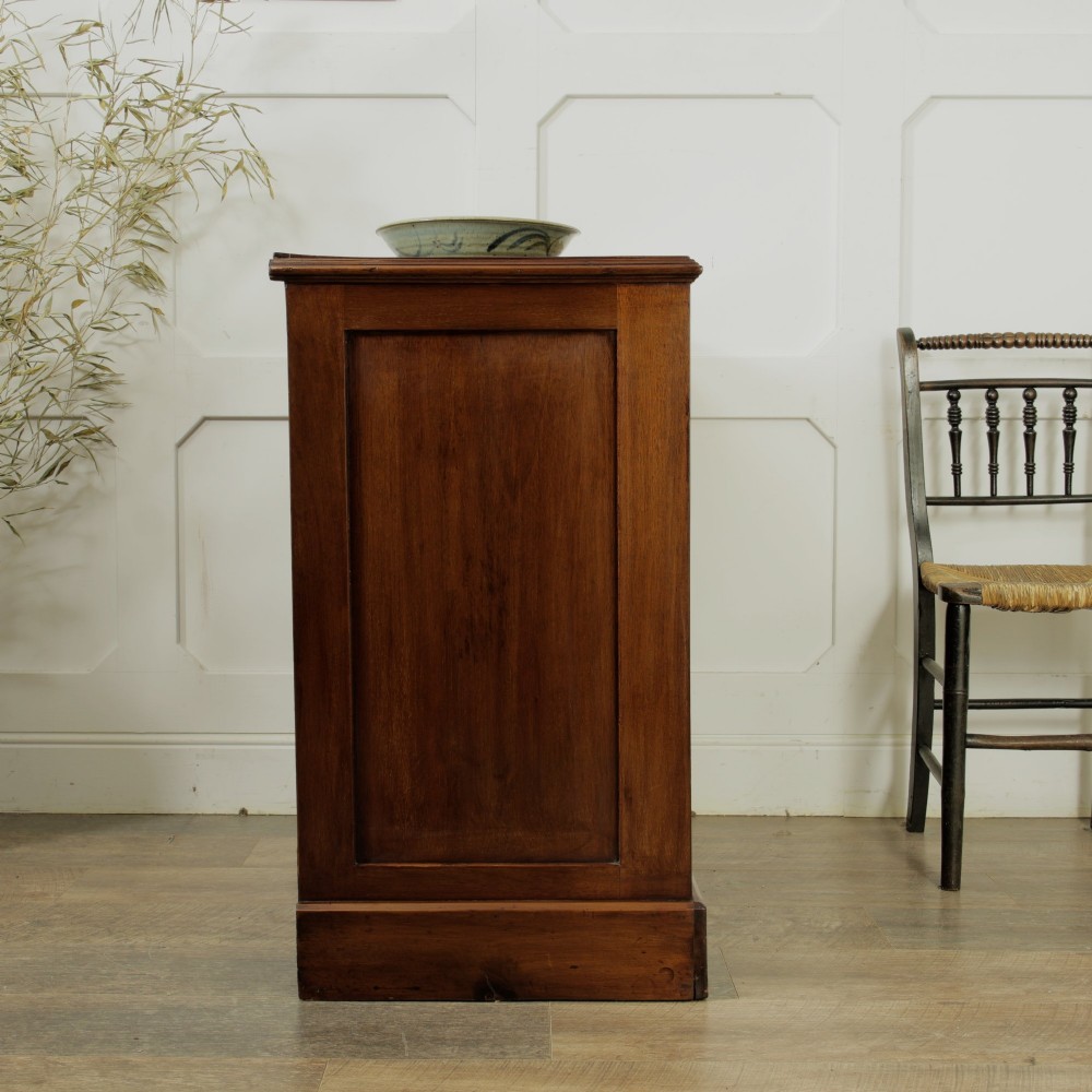 A late Victorian mahogany chest of drawers featuring two short drawers over two long drawers with brass handles on a plinth base. View VI