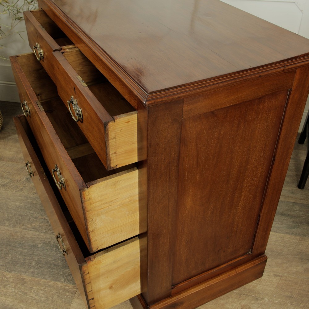 A late Victorian mahogany chest of drawers featuring two short drawers over two long drawers with brass handles on a plinth base. View IX