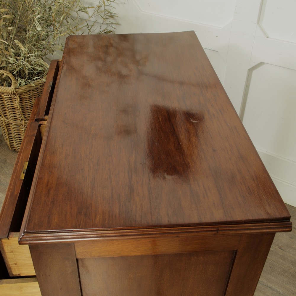 A late Victorian mahogany chest of drawers featuring two short drawers over two long drawers with brass handles on a plinth base. View X