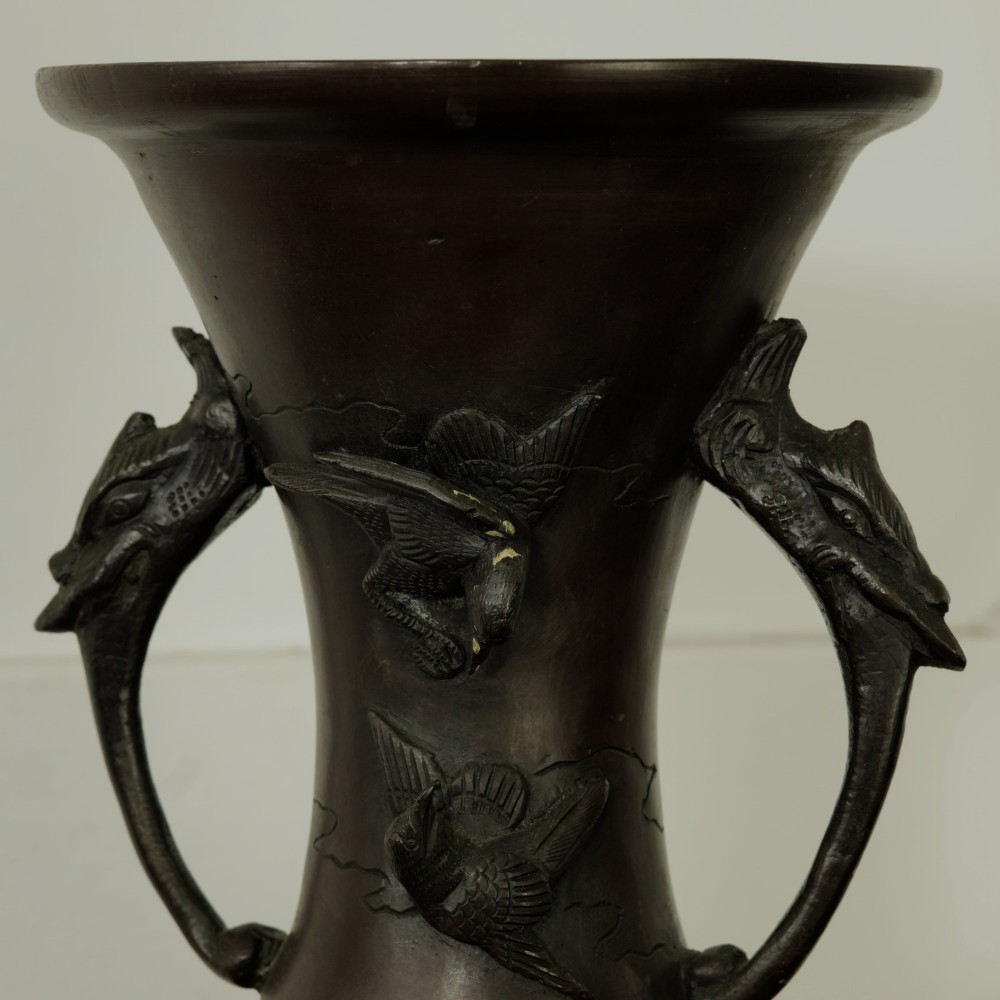 A dark brown patinated bronze vase featuring relief-carved bird motifs, flared neck, and twin dragon handles. View X