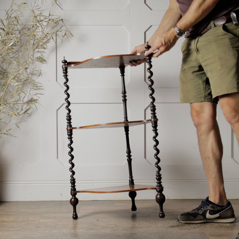 A Victorian mahogany corner whatnot featuring three shaped tiers supported by carved barley twist columns and turned finials. View II