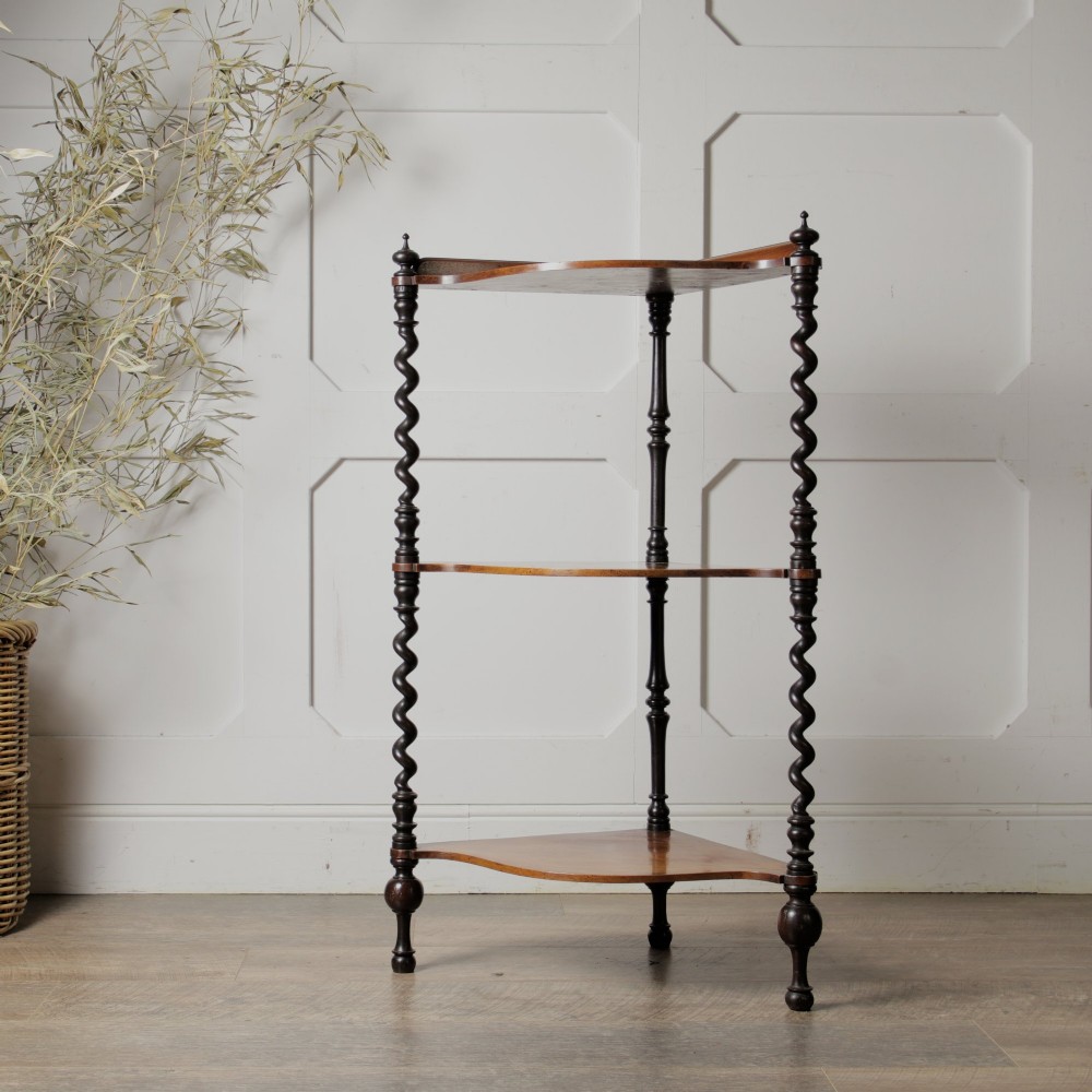 A Victorian mahogany corner whatnot featuring three shaped tiers supported by carved barley twist columns and turned finials. View V