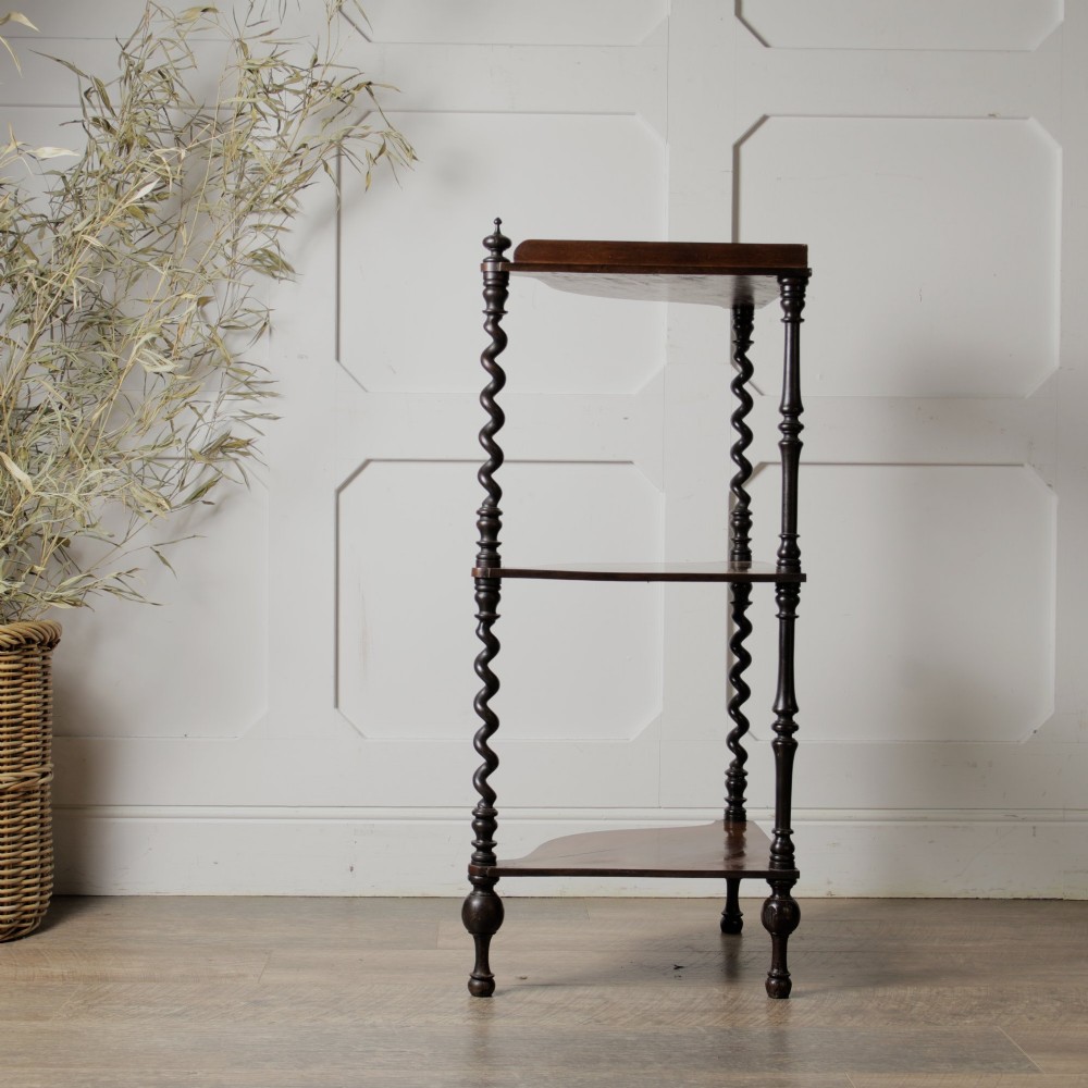 A Victorian mahogany corner whatnot featuring three shaped tiers supported by carved barley twist columns and turned finials. View VI