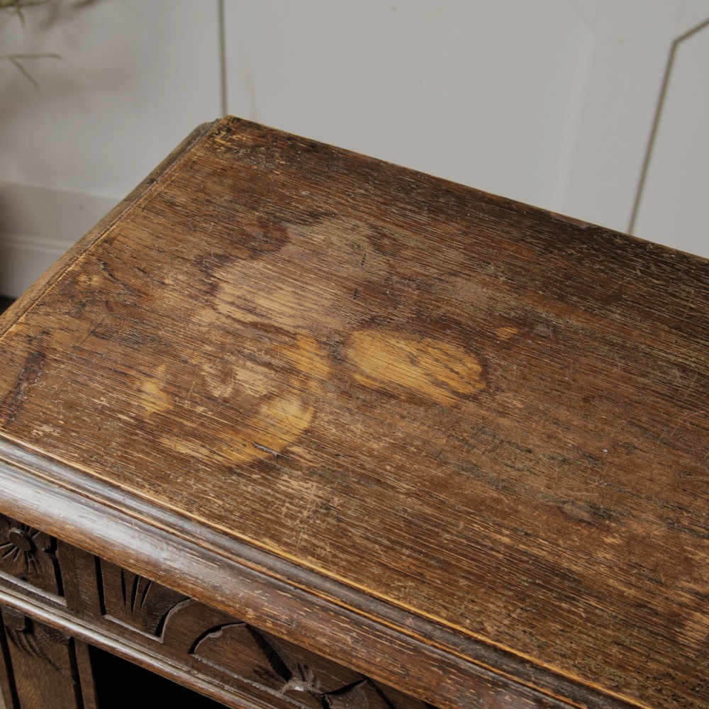 An early 20th-century dark oak open bookcase featuring a carved lunette frieze and three tiers of shelving. View VIII