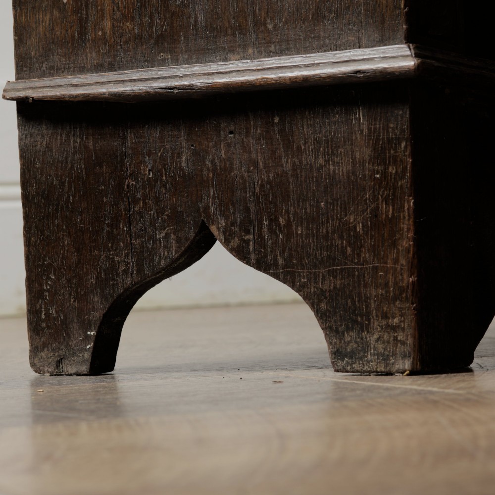 An early 20th-century dark oak open bookcase featuring a carved lunette frieze and three tiers of shelving. View XII