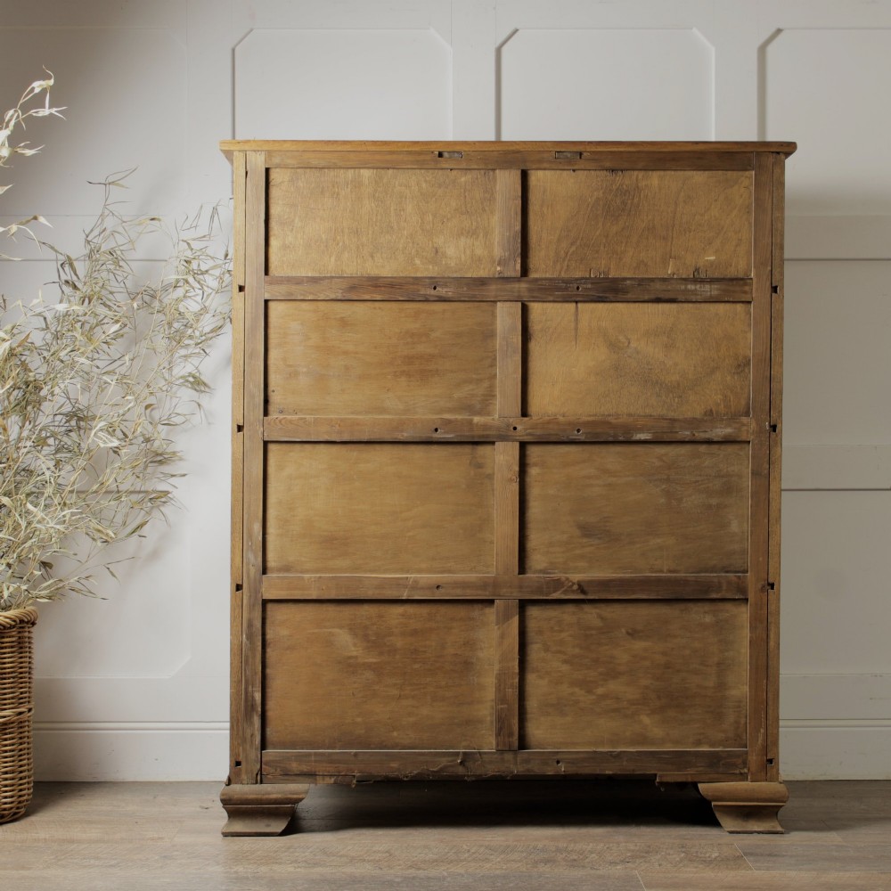 An early twentieth-century mellow oak glazed bookcase featuring twin glass-fronted doors over a lower cupboard with diagonal grain panels. View V