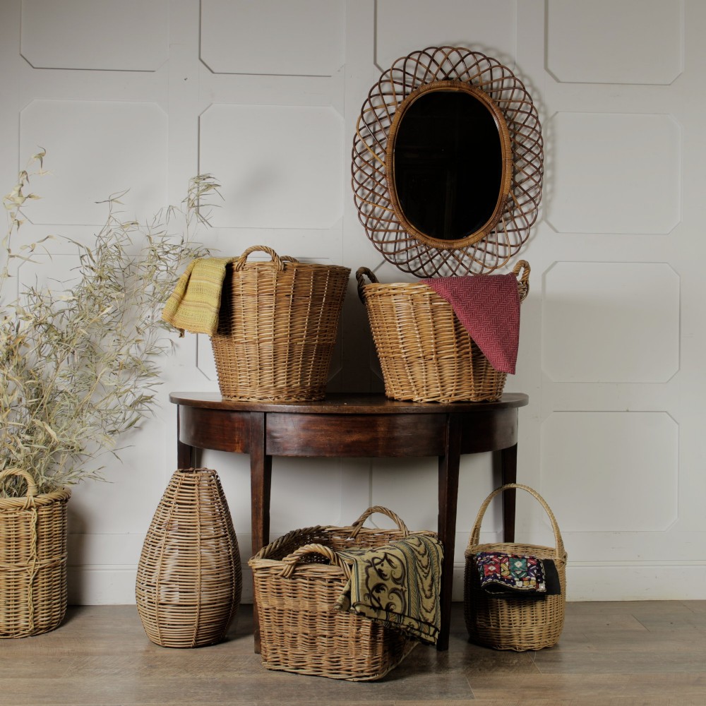 An oval mid-century wall mirror with an openwork outer frame crafted from woven, looped honey-toned rattan. View III