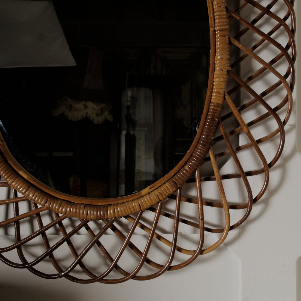 An oval mid-century wall mirror with an openwork outer frame crafted from woven, looped honey-toned rattan. View IV