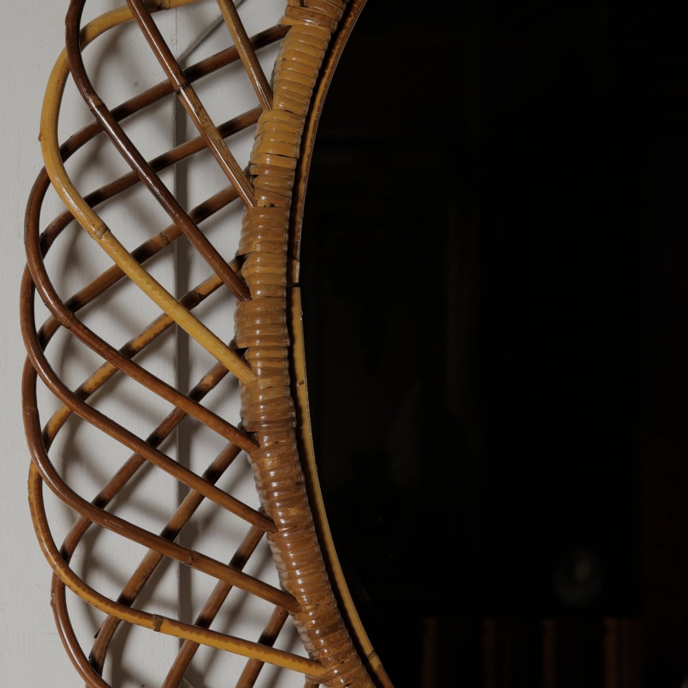 An oval mid-century wall mirror with an openwork outer frame crafted from woven, looped honey-toned rattan. View VI
