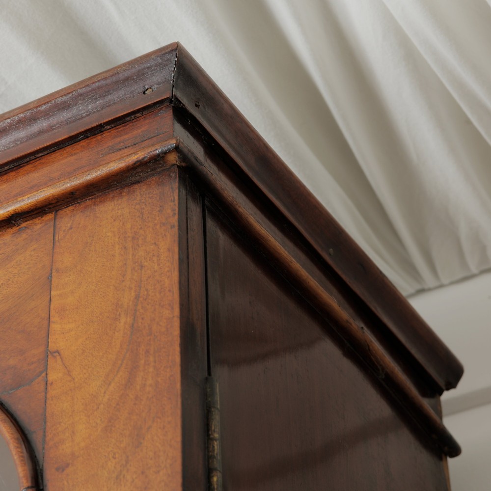 A two-tier Victorian mahogany chiffonier bookcase with arched glass double doors on the upper section and panelled cupboard doors on the lower base. View V