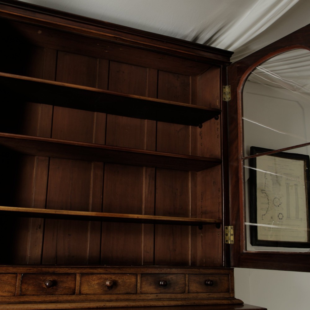 A two-tier Victorian mahogany chiffonier bookcase with arched glass double doors on the upper section and panelled cupboard doors on the lower base. View XIII