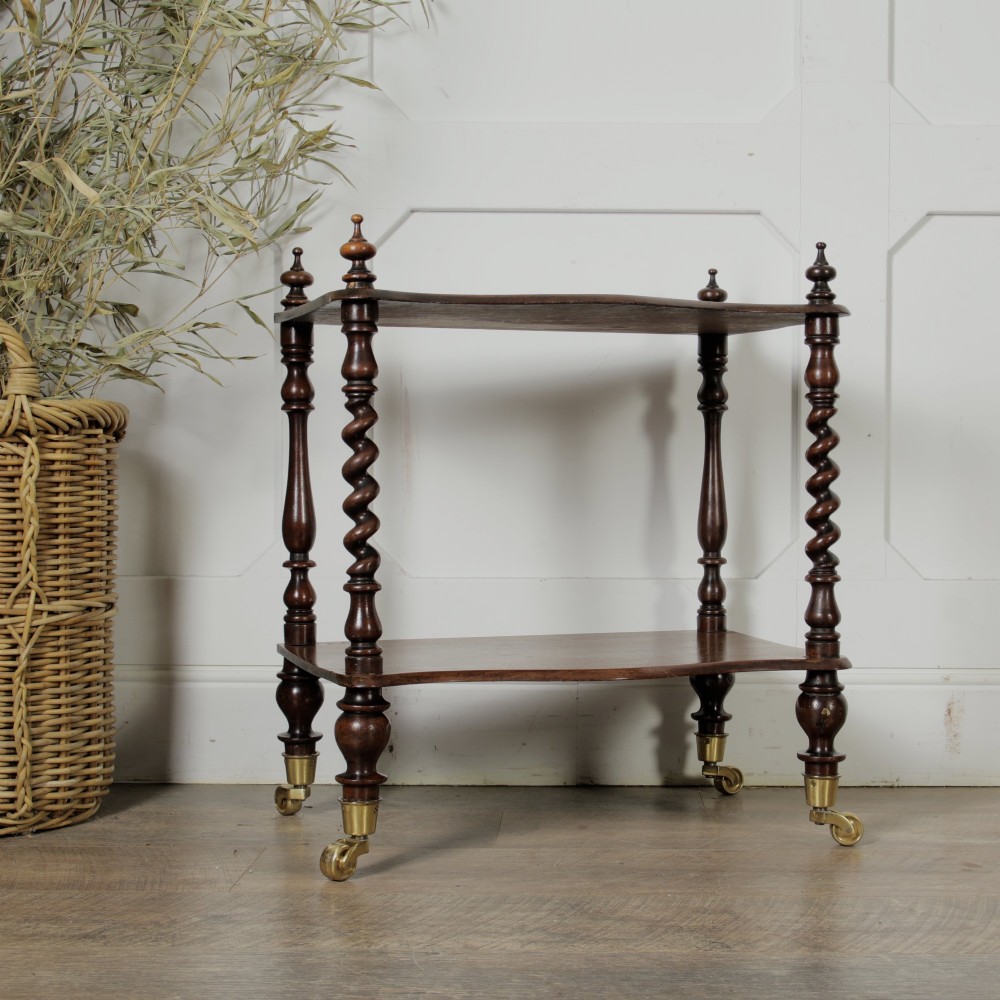 A dark wood Victorian two-tier whatnot featuring hand-turned barley twist legs, top corner finials, and brass casters. View II