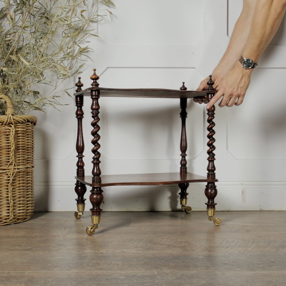 A dark wood Victorian two-tier whatnot featuring hand-turned barley twist legs, top corner finials, and brass casters. View III