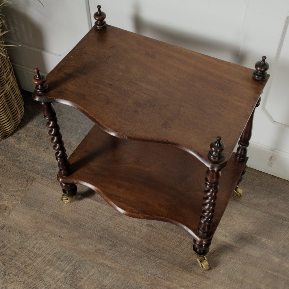A dark wood Victorian two-tier whatnot featuring hand-turned barley twist legs, top corner finials, and brass casters. View IV