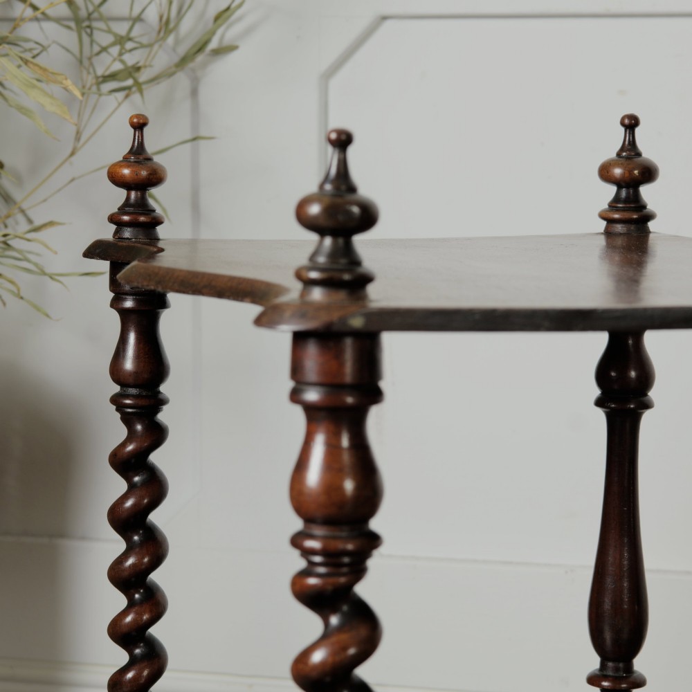 A dark wood Victorian two-tier whatnot featuring hand-turned barley twist legs, top corner finials, and brass casters. View VIII