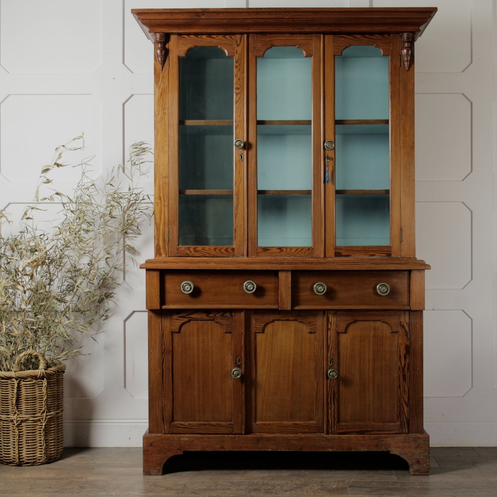A late Victorian stripped pitch pine glazed cupboard with a three-door glazed upper display section above two drawers and three lower panelled cabinet doors. View II