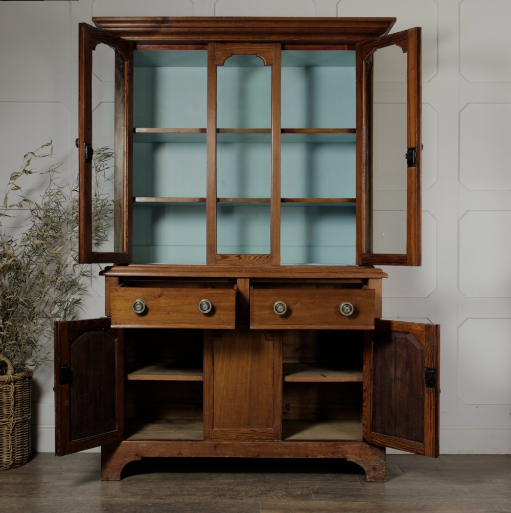 A late Victorian stripped pitch pine glazed cupboard with a three-door glazed upper display section above two drawers and three lower panelled cabinet doors. View III
