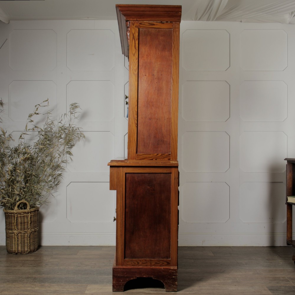 A late Victorian stripped pitch pine glazed cupboard with a three-door glazed upper display section above two drawers and three lower panelled cabinet doors. View IV