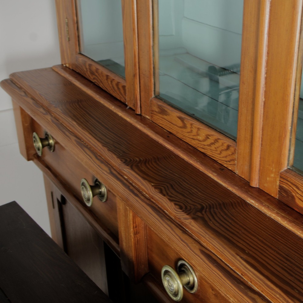A late Victorian stripped pitch pine glazed cupboard with a three-door glazed upper display section above two drawers and three lower panelled cabinet doors. View V