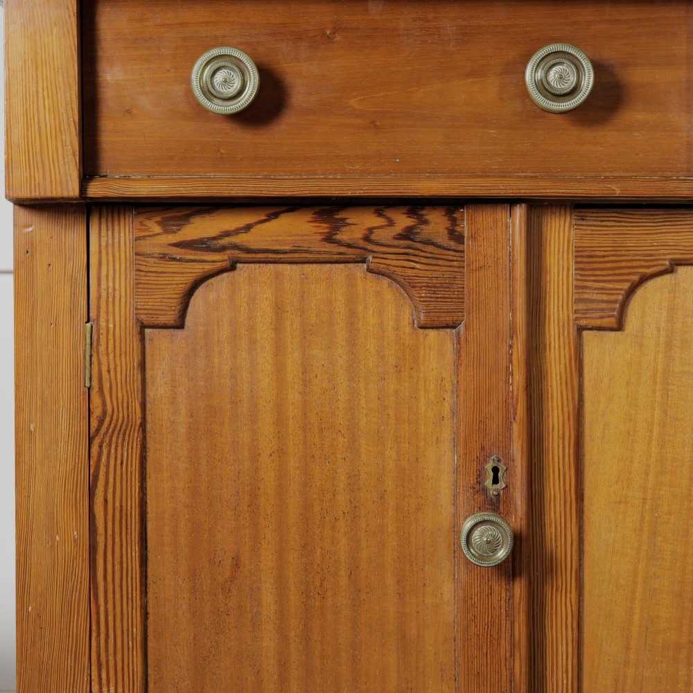 A late Victorian stripped pitch pine glazed cupboard with a three-door glazed upper display section above two drawers and three lower panelled cabinet doors. View VI