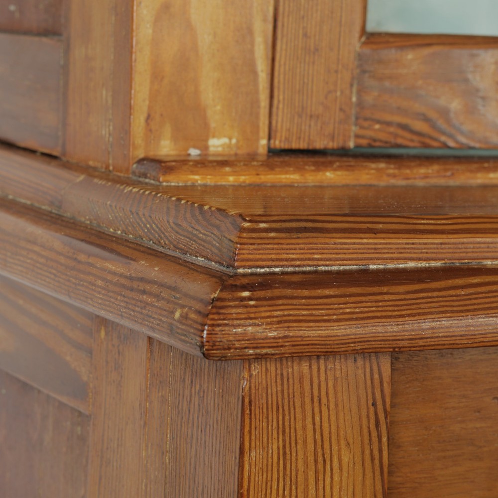 A late Victorian stripped pitch pine glazed cupboard with a three-door glazed upper display section above two drawers and three lower panelled cabinet doors. View VII