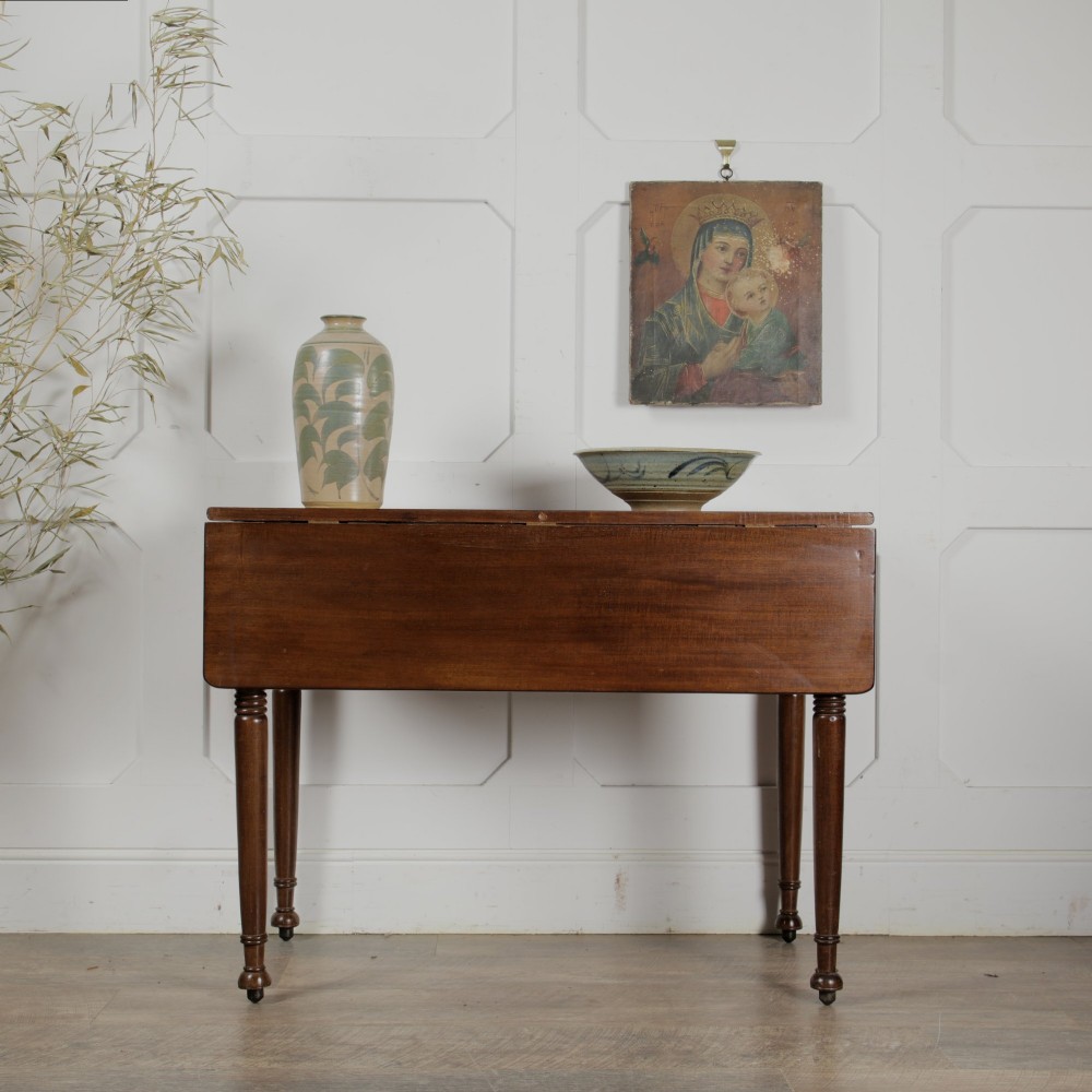 A Victorian mahogany drop-leaf table featuring a single hinged flap, turned legs, and small wheel castors. View II
