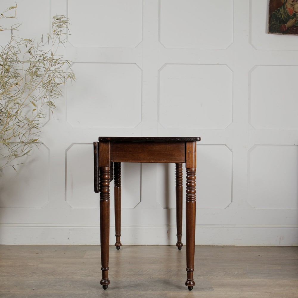 A Victorian mahogany drop-leaf table featuring a single hinged flap, turned legs, and small wheel castors. View III