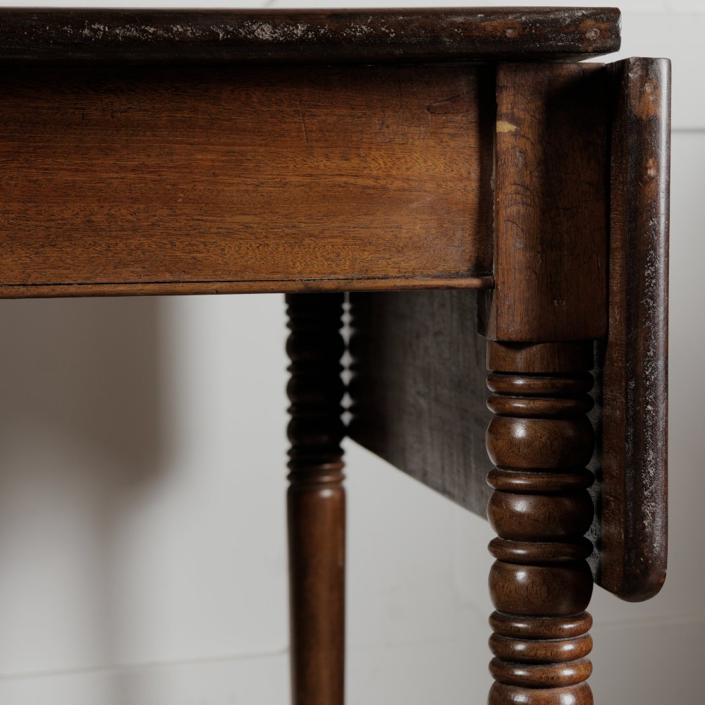 A Victorian mahogany drop-leaf table featuring a single hinged flap, turned legs, and small wheel castors. View IX