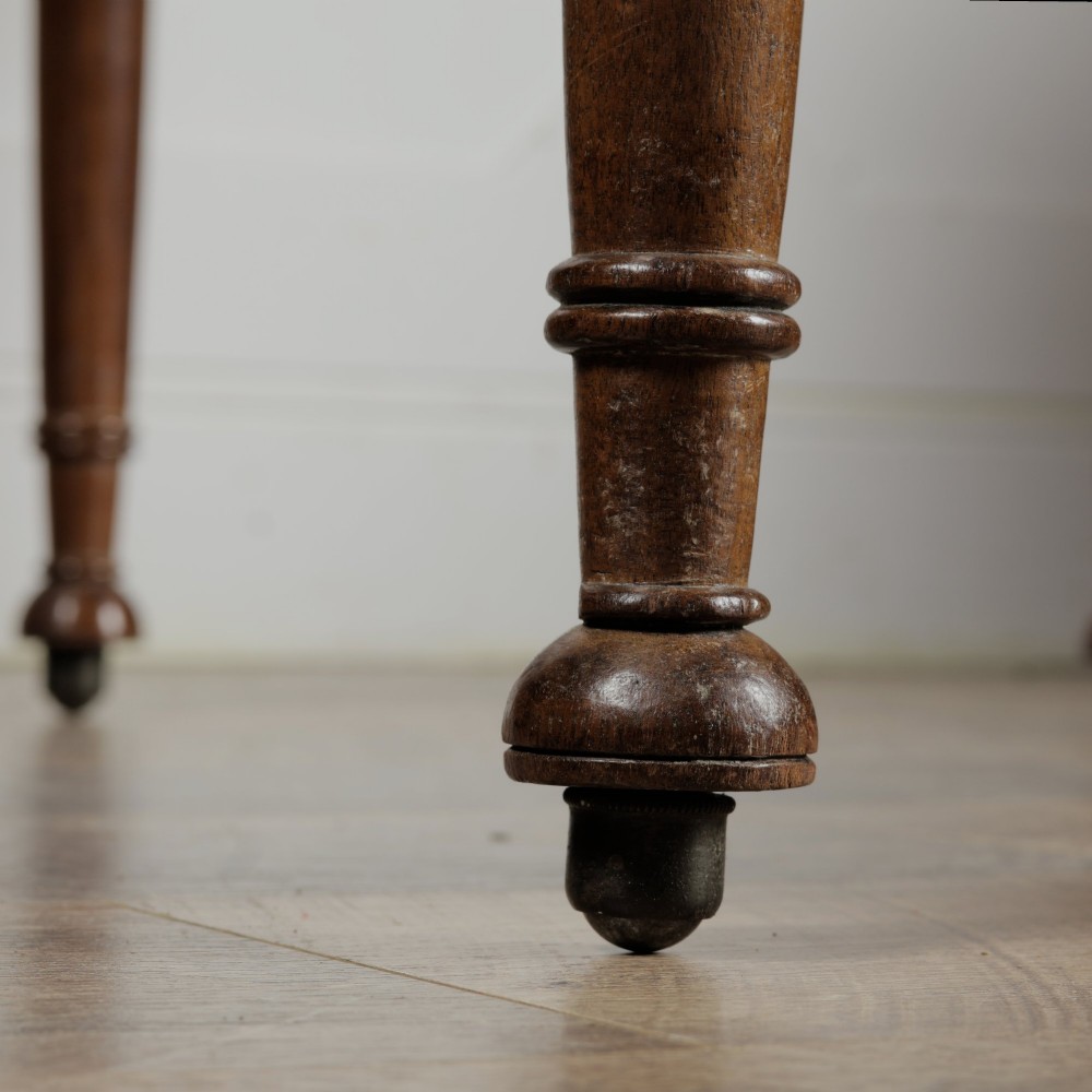 A Victorian mahogany drop-leaf table featuring a single hinged flap, turned legs, and small wheel castors. View XI