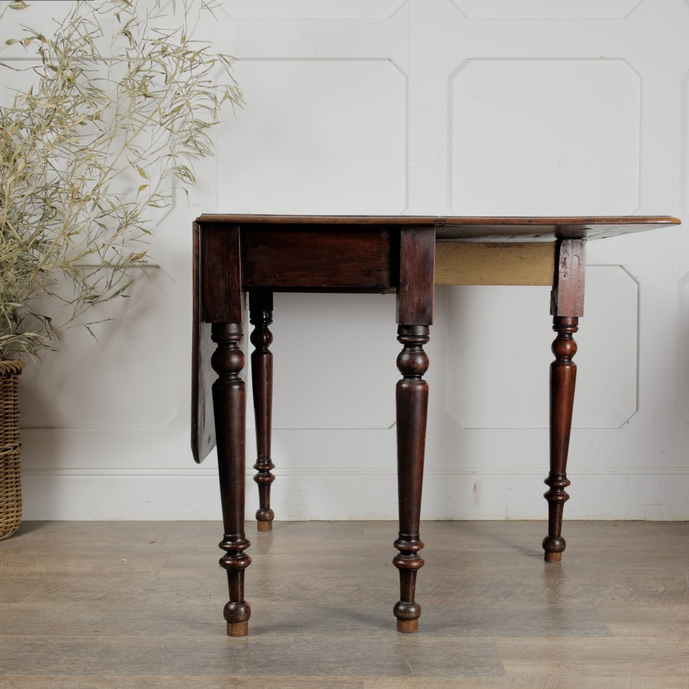 A Victorian mahogany gateleg table with two hinged drop leaves, a rectangular top, and turned wooden legs. View IV