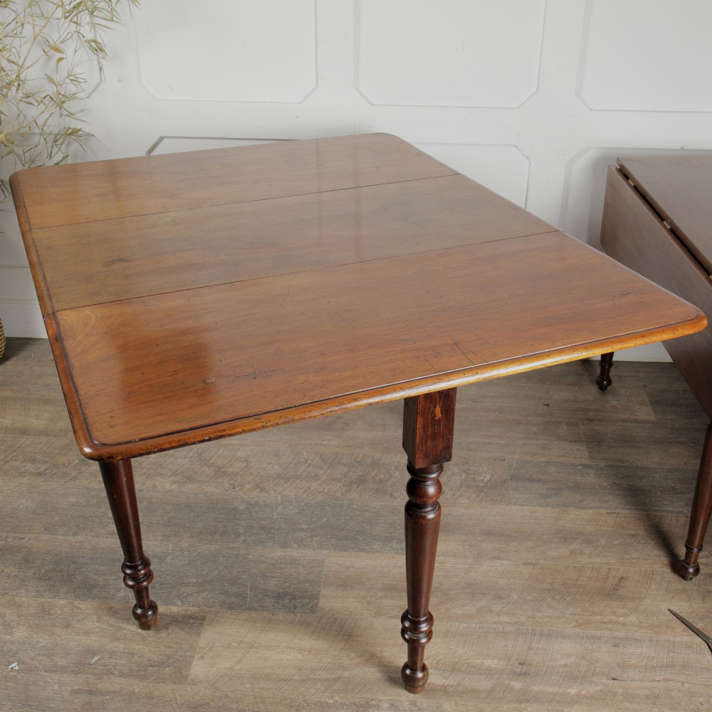 A Victorian mahogany gateleg table with two hinged drop leaves, a rectangular top, and turned wooden legs. View VI