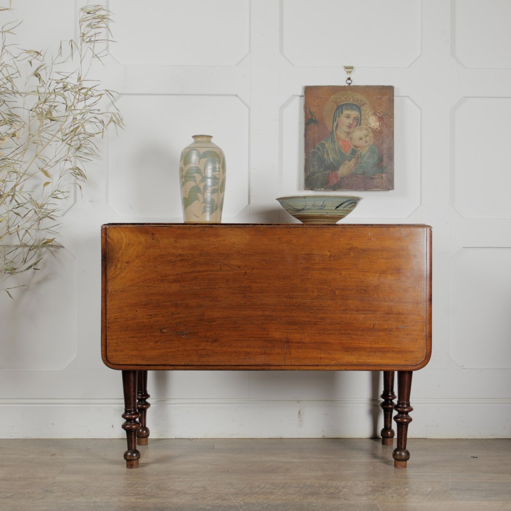 A Victorian mahogany gateleg table with two hinged drop leaves, a rectangular top, and turned wooden legs. View IX
