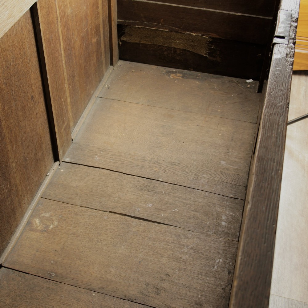 A large 18th-century dark oak mule chest featuring four arched fielded panels, three bottom drawers with brass drop handles, and a shaped apron. View VI