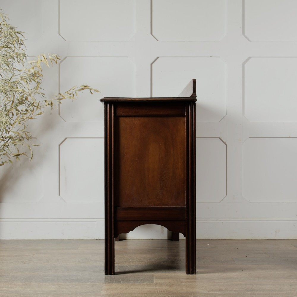 An Edwardian mahogany chest featuring three graduated drawers with drop handles, fluted side pilasters, and a low upstand. View III