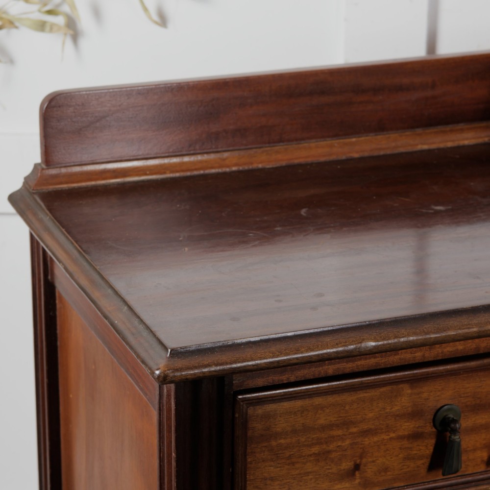 An Edwardian mahogany chest featuring three graduated drawers with drop handles, fluted side pilasters, and a low upstand. View VIII
