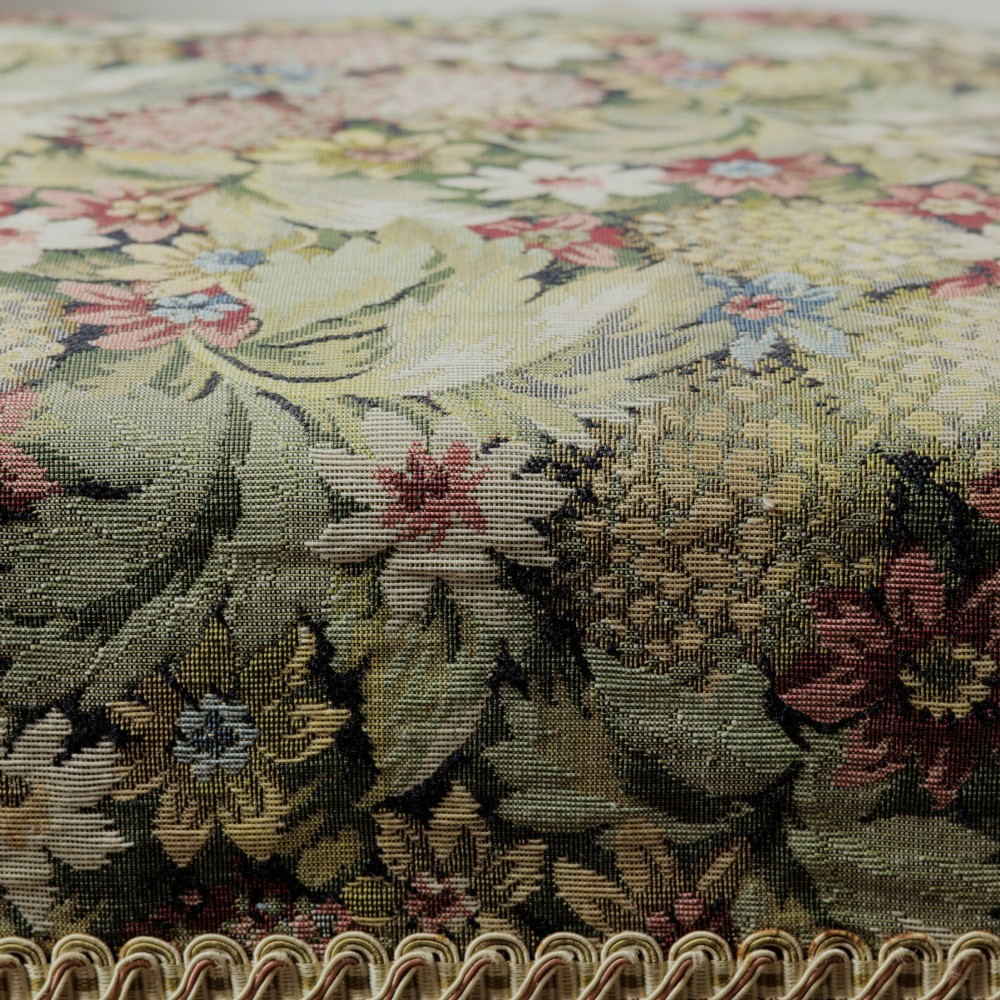 A low Victorian square footstool with green floral tapestry upholstery, decorative braid trim, and turned mahogany feet. View VIII