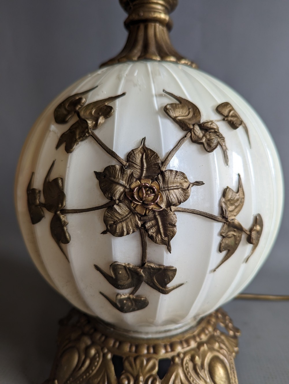 A white ribbed opaline glass table lamp featuring cast brass floral appliques, an ornate footed base, and a fluted metal neck. View III