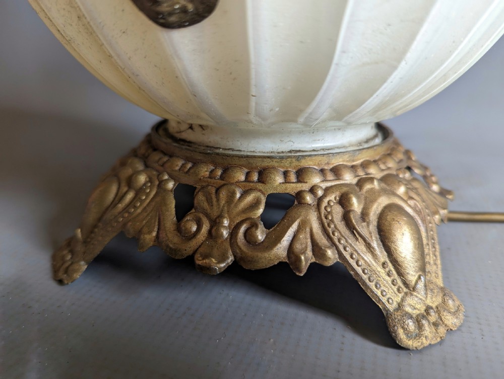 A white ribbed opaline glass table lamp featuring cast brass floral appliques, an ornate footed base, and a fluted metal neck. View IV
