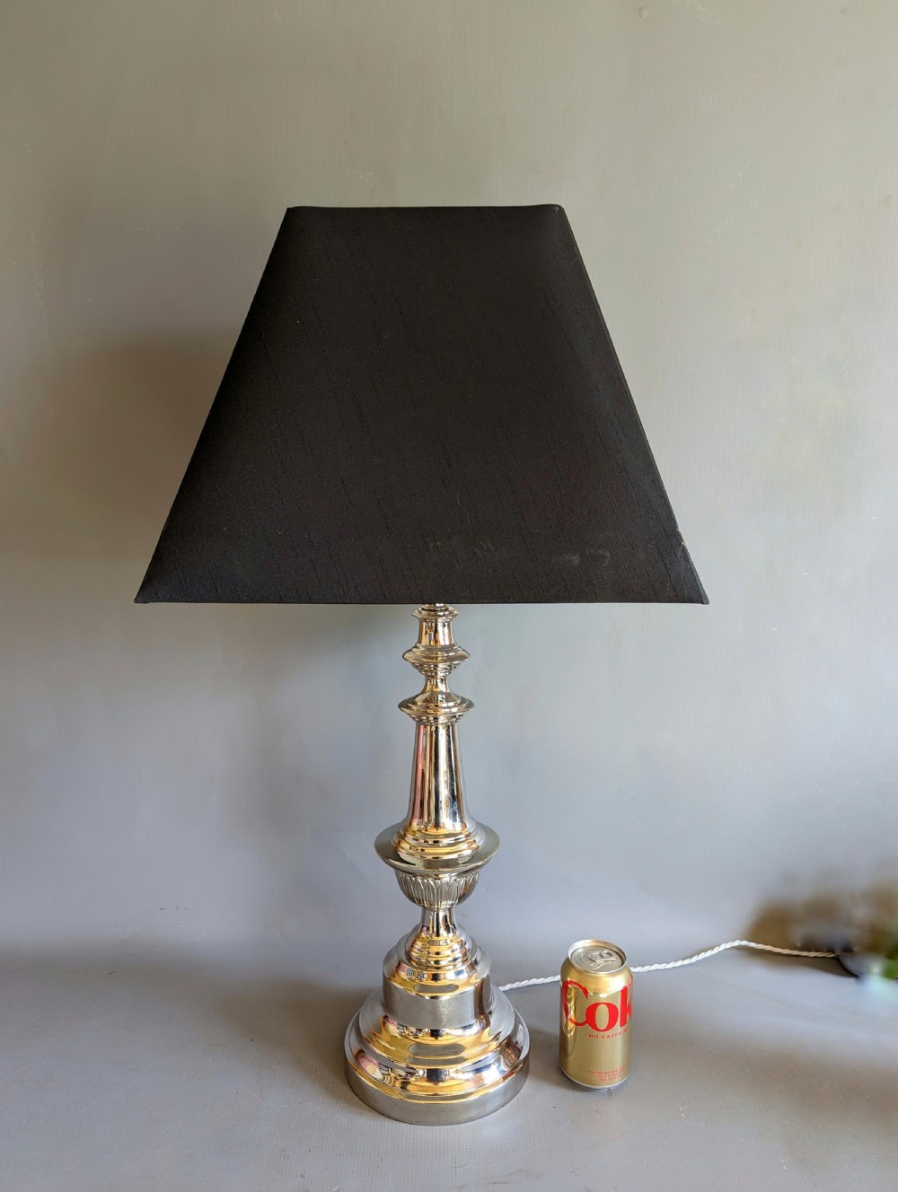 A pair of polished silver-toned metal table lamp bases featuring stepped circular bases and turned baluster columns. View II