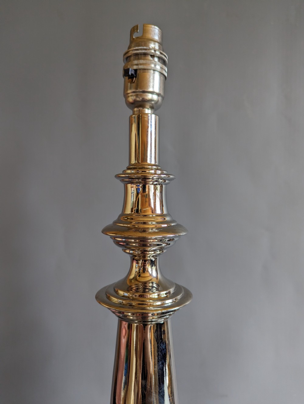 A pair of polished silver-toned metal table lamp bases featuring stepped circular bases and turned baluster columns. View VII