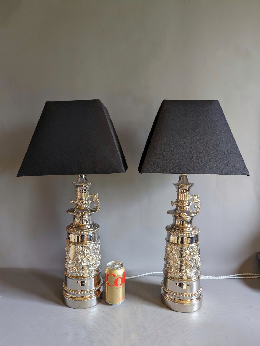 A pair of reflective nickel-plated table lamps featuring embossed foliate relief, scroll handles, and beaded rim details. View III