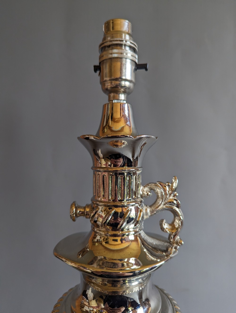 A pair of reflective nickel-plated table lamps featuring embossed foliate relief, scroll handles, and beaded rim details. View VIII
