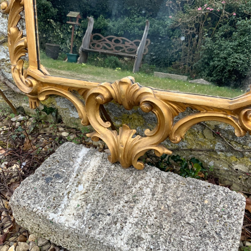 An early 19th-century rectangular mirror set within a gold giltwood frame featuring carved acanthus leaves, scrollwork, and floral motifs. View II
