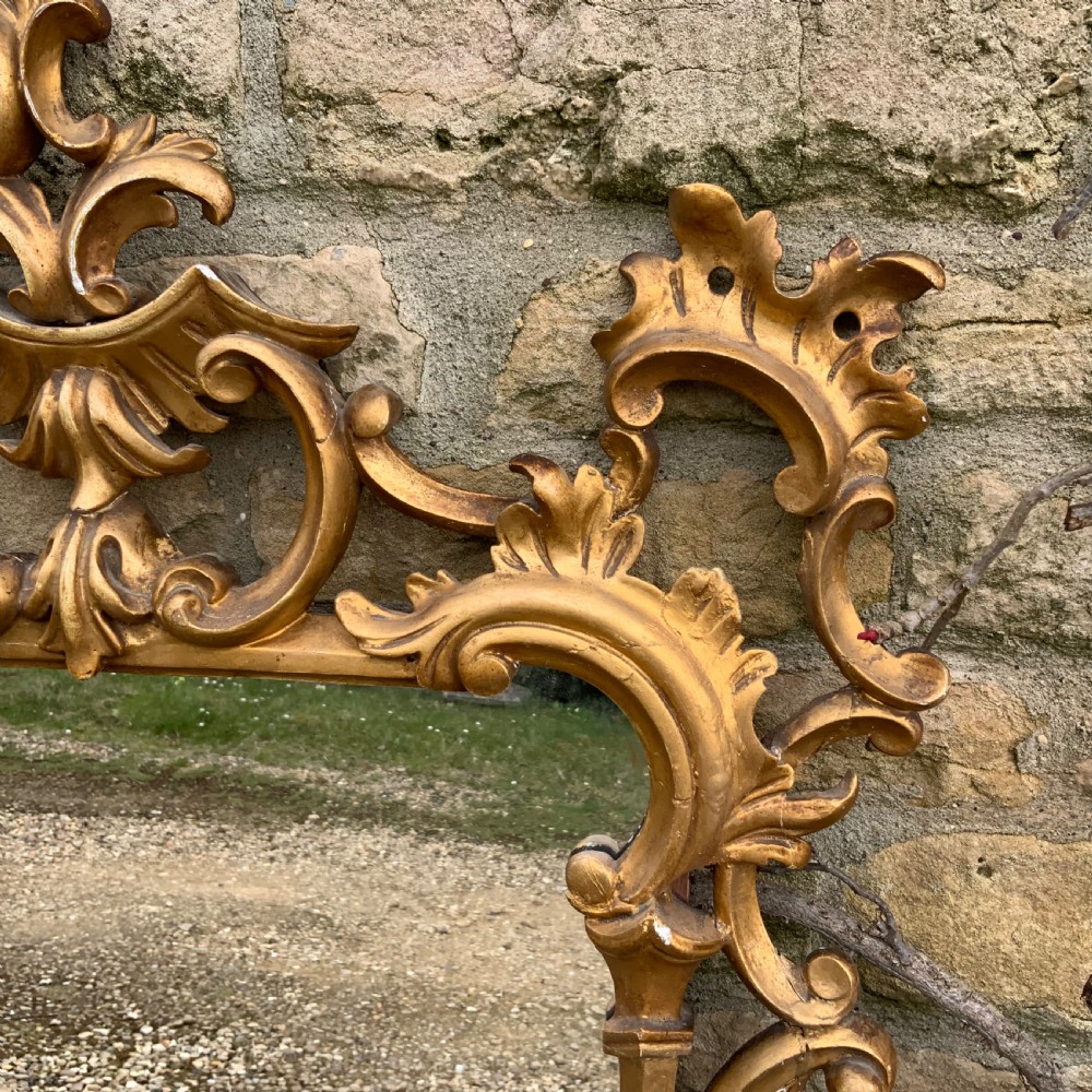 An early 19th-century rectangular mirror set within a gold giltwood frame featuring carved acanthus leaves, scrollwork, and floral motifs. View III