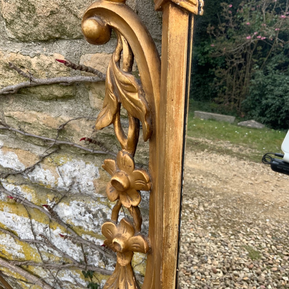 An early 19th-century rectangular mirror set within a gold giltwood frame featuring carved acanthus leaves, scrollwork, and floral motifs. View IV