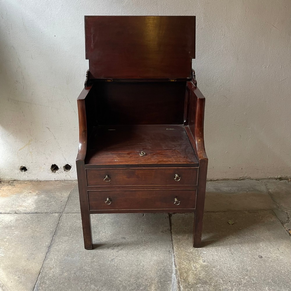 A George III mahogany bedside commode featuring an upper open compartment, gallery top, and lower drawers with brass handles. View III