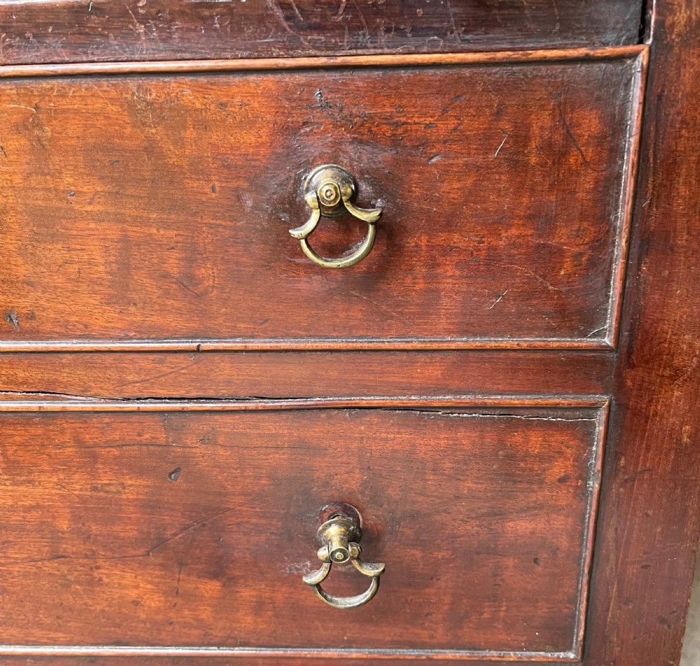 A George III mahogany bedside commode featuring an upper open compartment, gallery top, and lower drawers with brass handles. View V