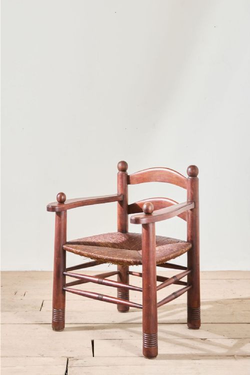 fig 1. A low Charles Dudouyt French modernist armchair made from turned oak wood with a woven rush seat and spherical post finials.