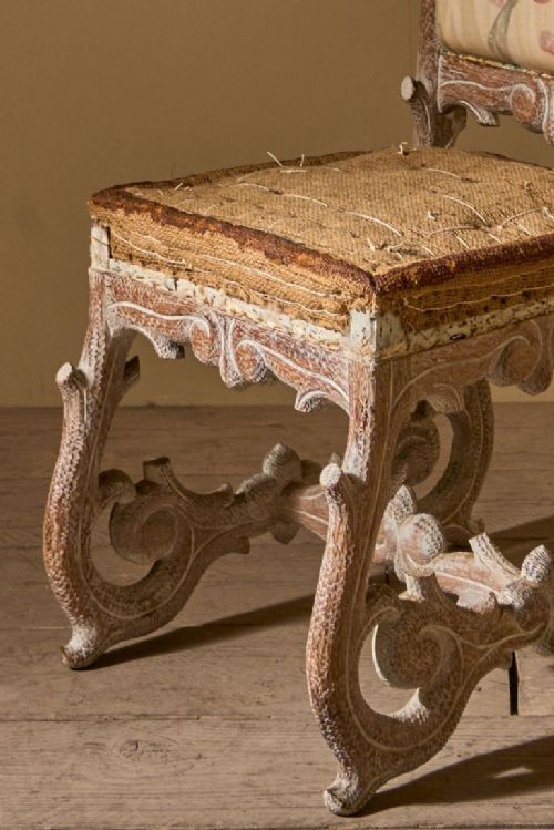 fig 1. A 19th-century faux bois side chair featuring a distressed off-white painted frame, branch-like carvings, scroll legs, and floral fabric upholstery on the backrest and seat.